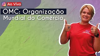 "OMC: Organização Mundial do Comércio" escrito sobre fundo verde ao lado da imagem da professora