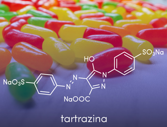 Balas coloridas e a fórmula molecular da tartrazina, um tipo de amina aromática.