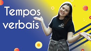 Professora ao lado do texto"Tempos verbais"