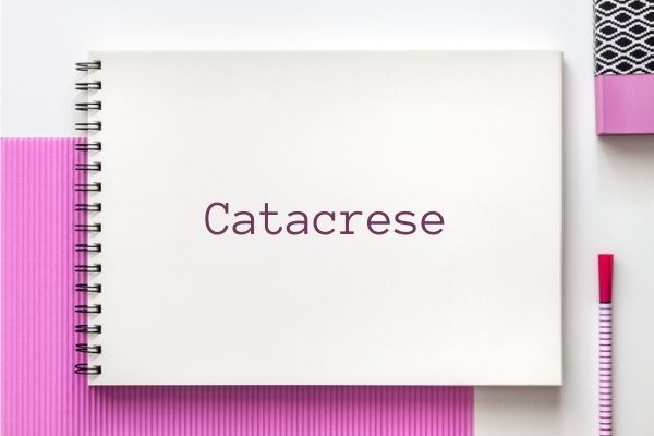 Palavra “Catacrese” escrita sobre caderno em fundo rosa e branco