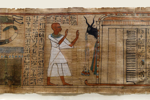 Folha de papiro preenchida com hieróglifos em superfície clara