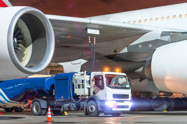 Caminhão abastecendo avião com querosene