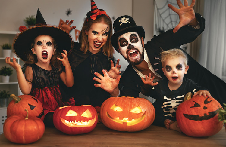 Família, formada por quatro pessoas, vestida em fantasias de Halloween (Dia das Bruxas).