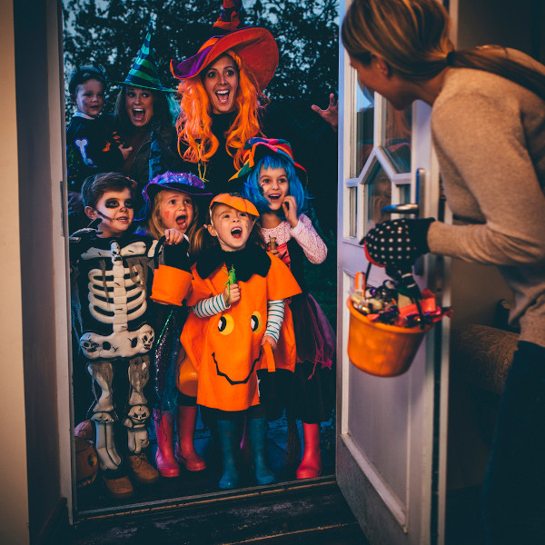 Crianças fantasiadas pedindo doces no Halloween (Dia das Bruxas).