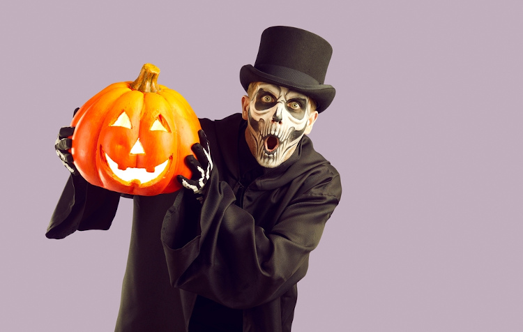 Homem com fantasia de esqueleto para celebrar o Halloween (Dia das Bruxas).