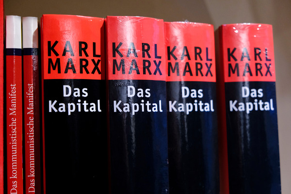Volumes em alemão do livro O Capital, de Karl Marx, enfileirados em uma prateleira.