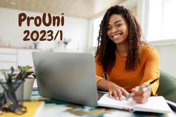 Estudante negra sorrindo em frente ao computador Texto ProUni 2023/1