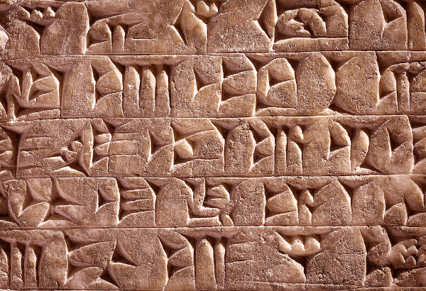 Escrita cuneiforme, típica dos sumérios e dos assírios, geralmente esculpida em argila ou pedra.