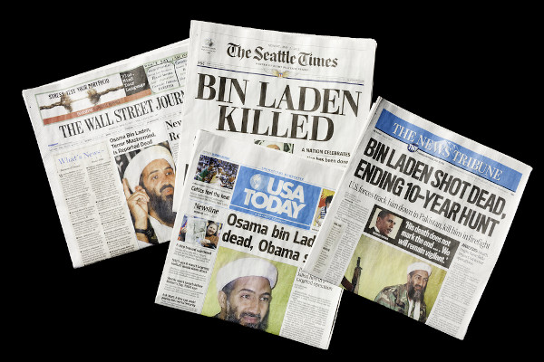 Jornais impressos com fotos de Osama bin Laden e a notícia de sua morte, escrita em inglês.