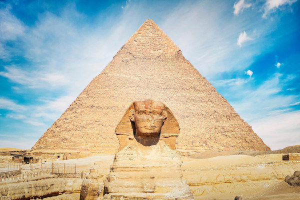 A Esfinge, um dos grandes símbolos da civilização egípcia, diante de pirâmide.