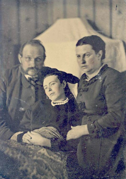 Pais posam com a filha falecida. Fotografias post mortem eram comuns na Era Vitoriana.