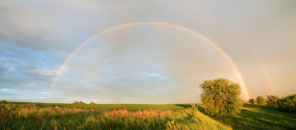 Arco-íris em paisagem rural.
