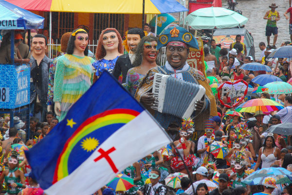 Bonecos de Olinda e foliões no Carnaval, festa da cultura brasileira.