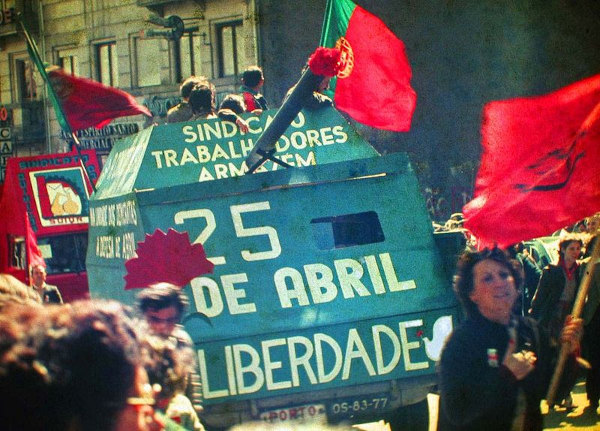 Desfile de civis e tanque durante celebração de aniversário da Revolução dos Cravos, em Portugal.