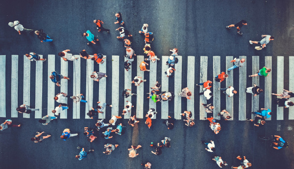 Vista aérea de pessoas caminhando sobre faixa de pedestres, em texto sobre sociologia.