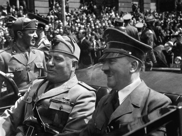 Mussolini e Hitler, líderes da extrema-direita, em passeio de carro na Alemanha, rodeados por uma multidão.