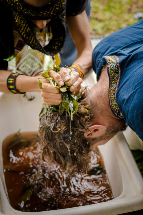 Homem recebendo banho de erva em ritual do xamanismo.