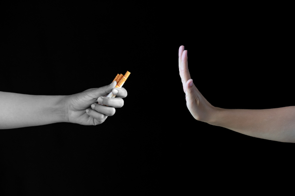 Mãos oferecendo e rejeitando cigarro em alusão ao Dia Nacional de Combate ao Fumo.