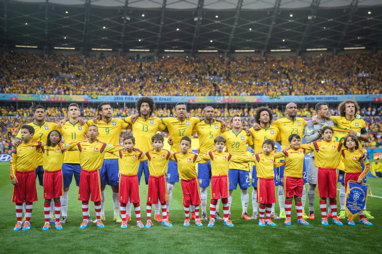 Seleção Brasileira de Futebol cantando o Hino Nacional Brasileiro antes de uma partida de futebol.