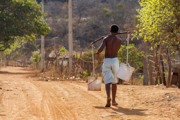 Garoto transportando água em baldes, em texto sobre tratamento de água. 