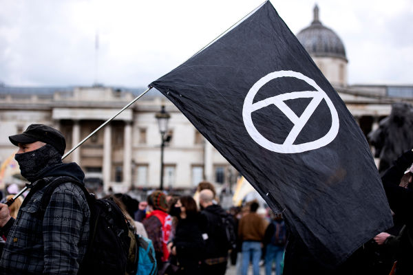 Manifestantes usam símbolo do anarquismo em protestos, em Londres.