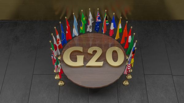 Mesa, com o escrito G20, rodeada pela bandeira dos países que integram esse fórum de cooperação econômica internacional.