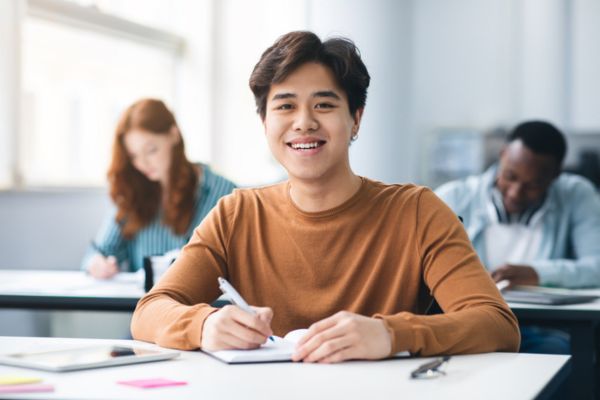 Jovem sorri em referência às inscrições do Fies 2025.