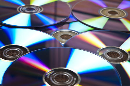 Os dados, que serão lidos por um leitor óptico, são gravados nas ranhuras da face lisa dos CDs e DVDs