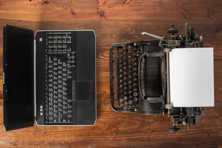 Notebook de frente a máquina de escrever em referência aos meios de comunicação.